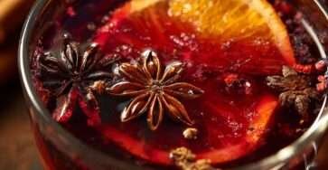 Verres de cocktail de Noël au jus de raisin, rhum et épices avec rondelle d’orange