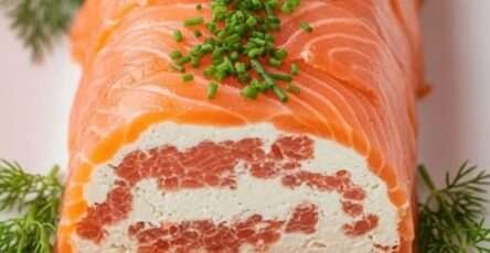 Roulé de saumon fumé farci au fromage frais aux herbes, tranché en rondelles sur un plat de fête