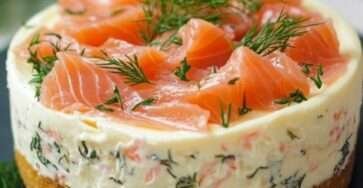 Cheesecake au saumon fumé sur base de biscuits salés, décoré de ciboulette fraîche dans une assiette raffinée