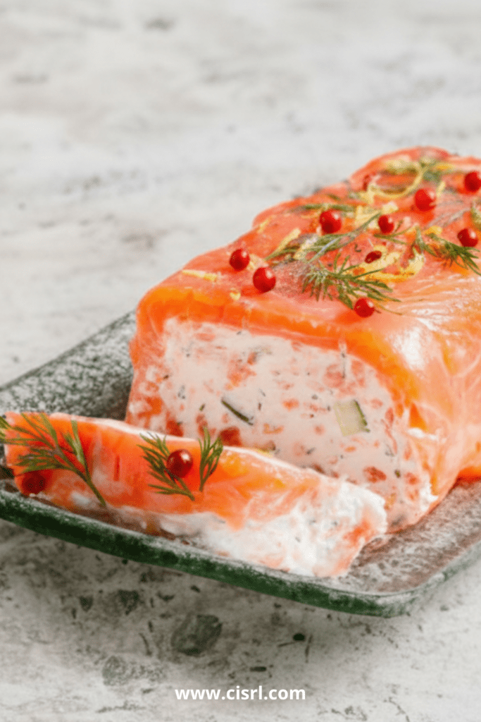 Tranches de bûche salée au saumon fumé et frais, au fromage de chèvre et concombre, décorées d’aneth et de citron vert sur un plat de fête