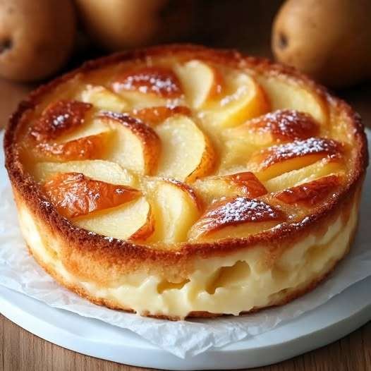 Flan aux pommes et yaourt doré dans un moule rond, posé sur une table en bois