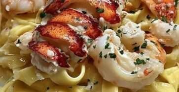 Assiette de tagliatelles Alfredo au homard et crevettes avec sauce crémeuse au parmesan