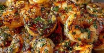 Crevettes sautées à l’ail et aux herbes dans une poêle, nappées d’huile d’olive et de persil frais