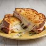 Croque jambon fromage ultra coulant doré à la poêle et coupé en deux avec fromage filant