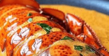 Queues de homard servies dans leur carapace, nappées de sauce homardine au Cognac, avec accompagnement raffiné sur assiette de fête