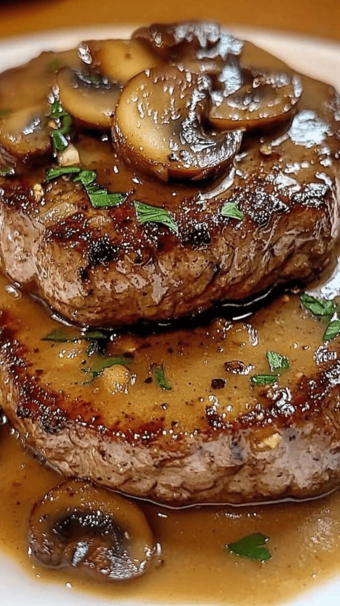 Steaks de bœuf nappés d’une sauce crémeuse aux champignons dans une poêle